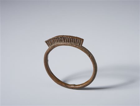  Arte africana - Ibo, Nigeria.
Bracciale-Moneta in bronzo. 
Segni d'uso. .