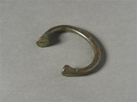  Arte africana - Okpogho, Nigeria.
Bracciale-moneta Manilla.
Lega di rame.
Con ottima patina e segni d'uso. .