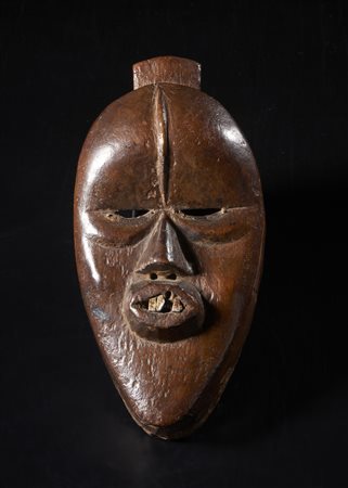  Arte africana - Dan, Costa d'Avorio.
Maschera Deagle. 
Legno duro a patina marrone, alluminio.
Segni d'uso.