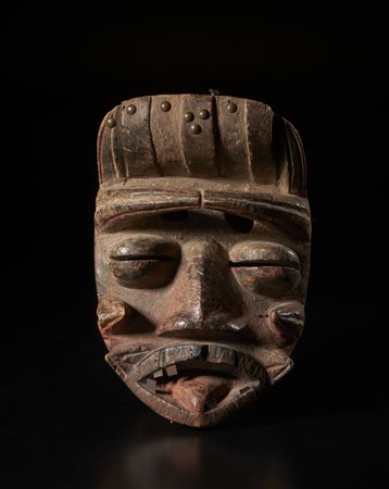  Arte africana - Guerè, Costa d'Avorio/Liberia. 
Maschera in legno duro a patina naturale con pigmenti. ferro, chiodi e borchie in ottone.
Difetti visibili ed  evidenti  segni d'uso.