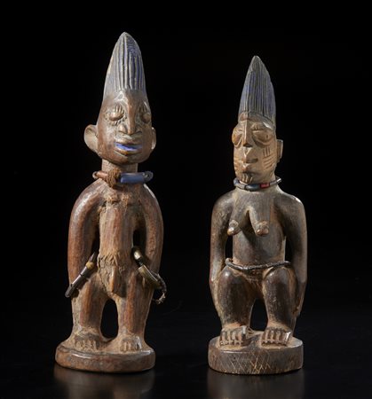  Arte africana - Yoruba, Nigeria. 
Due gemelli ibeji in legno duro a patina chiara, perline, fibre e pigmenti. 
Segni d'uso. .