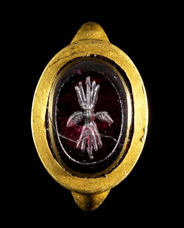 A LATE GREEK HELLENISTIC GOLD RING WITH A GARNET INTAGLIO. THUNDERBOLT. 