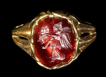A ROMAN GARNET INTAGLIO SET IN A LATER GOLD RING. NIKE. 