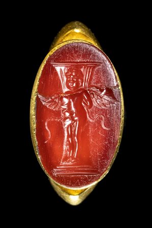 A FINE ROMAN GOLD RING SET WITH A CARNELIAN INTAGLIO. EROS PRISONER.