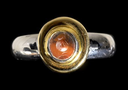 AN ITALIC CARNELIAN INTAGLIO SET IN A MODERN BICOLOR GOLD RING. POMEGRENATE. 