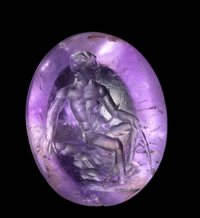 A ROMAN AMETHYST INTAGLIO. SEATED MALE FIGURE. 