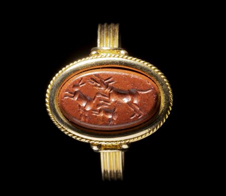 A ROMAN RED JASPER INTAGLIO SET IN A GOLD RING. HUNTING SCENE. 