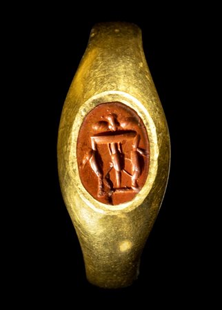 A ROMAN GOLD RING SET WITH A RED JASPER INTAGLIO. A SMALL TABLE WITH VESSELS (TRAPEZA). 