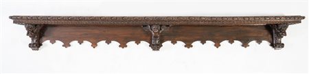 Mensola in massello di noce intagliato. Il piano è profilato da una cornice...