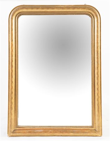 Specchiera in legno intagliato e dorato. Cornice modanata con perlinatura che...
