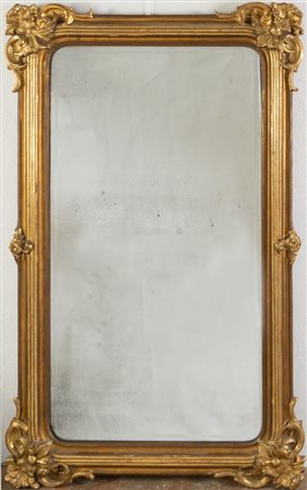 Specchiera in legno intagliato e dorato, con applicazioni in pastiglia...