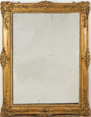 Specchiera in legno intagliato e dorato, con applicazioni in pastiglia...