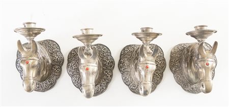 Lotto composto di quattro portacandele a forma di testa di cavallo in metallo...