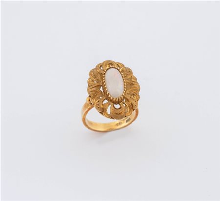 Anello in oro giallo 18K inciso e traforato, centrato da cabochon ovale...