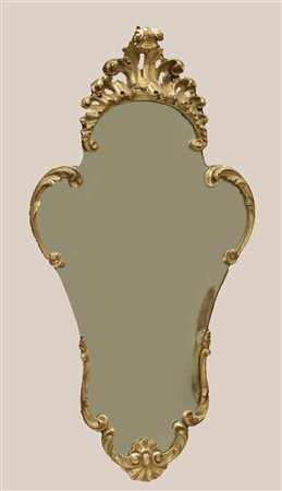  
Specchiera veneziana della prima metà del XX secolo, composta da elementi in legno finemente sagomati, intagliati e dorati. 
 cm 63x45