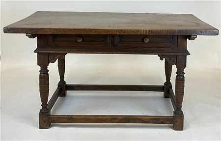 Tavolo scrittoio in noce con fronte a due cassetti, gambe a balaustro raccordat