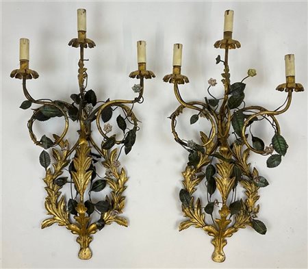Coppia di applique in metallo dorato e dipinto a tre fiamme decorate a foglie e