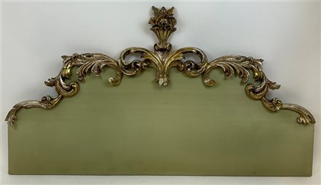 Testata di letto con cimasa in legno intagliato e dorato a mecca, decoro a volu