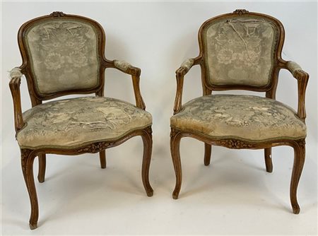 Coppia di poltrone in stile Luigi XV di forma mossa in legno intagliato, bracci