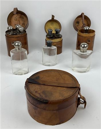 Nove porta profumi in vetro con tappi in metallo entro tre custodie di forma ci