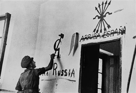 Robert Capa - Gerda Taro (1913-1954, 1910-1937)  - A member of the Internatinal Brigade applies some of his propaganda in a village wall, 1936/1939