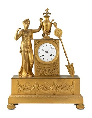 Orologio da appoggio in bronzo dorato. Cassa decorata da figura femminile con e