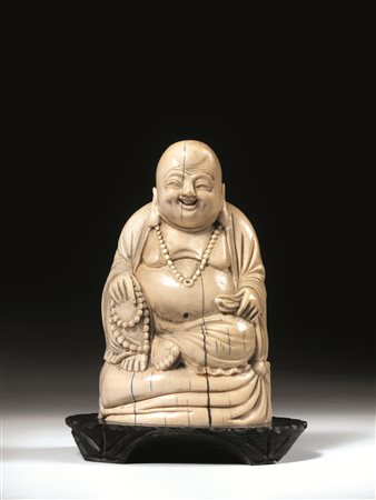 Buddha, Cina sec. XIX, in avorio, reggente una collana, su base in legno,...