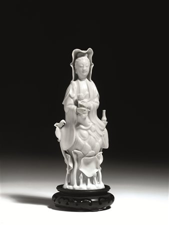 Guanyin, Cina inizi sec. XX, in porcellana blanc de Chine, stante su base a...