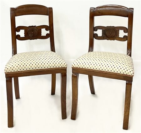 Coppia di sedie in noce con schienale centrato da cartella intagliata a rosone,