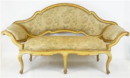 Divano a ventaglio in legno intagliato, laccato e dorato. Schienale a volute co