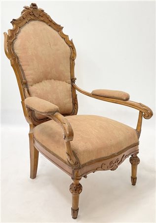 Poltrona in noce intagliato con schienale sagomato e cimasa centrata da stemma