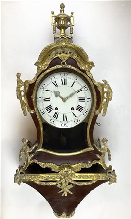 Orologio del tipo Neuchatelois con mensola in legno laccato e metallo dorato. Q