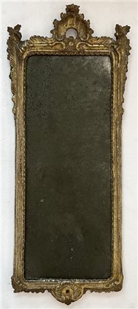 Specchiera in legno intagliato e dorato a mecca con cimasa traforata a volute r