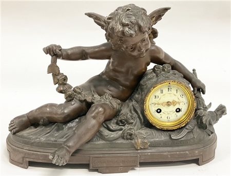 Pendola con cassa in antimonio patinato a figura di amorino, quadrante in smalt