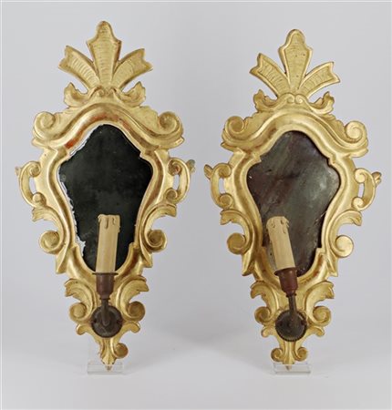 Coppia di ventole a una luce con bracci in metallo, cornici in legno intagliato