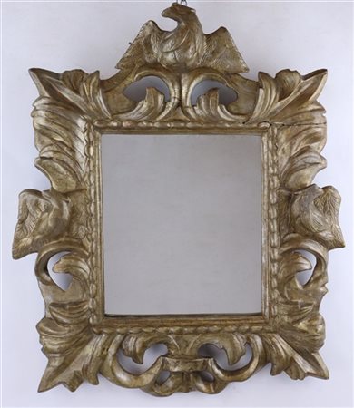 Specchiera con cornice in legno intagliato, traforato e argentato a volute fogl