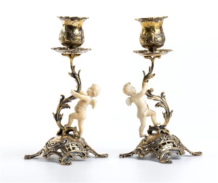  
Coppia di candelieri in argento e avorio Germania, fine XIX secolo, Hanau (?)
 Altezza x larghezza x profondità: 15,9 x 6,9 x 6,9 cm; dimensioni sculture in avorio: 6 x 3,5 x 2 cm. Peso complessivo 249,70 gr.