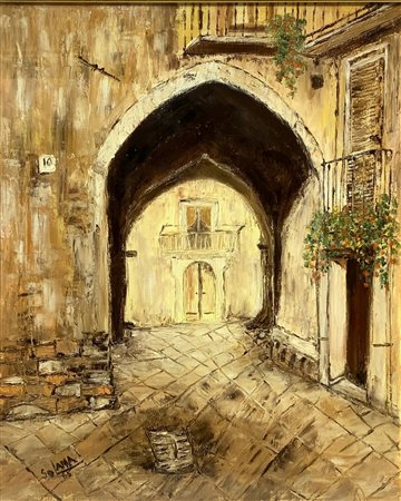 Strada di paese con arco a sesto acuto.