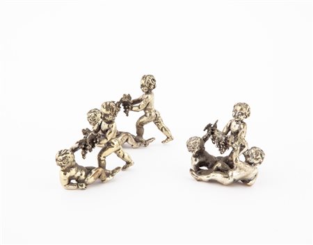 Tre piccoli gruppi in argento raffiguranti puttini con grappoli d'uva