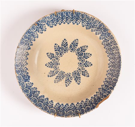 Grande piatto da portata con decoro a spugnetta blu sulla tesa e sole raggiato nel cavetto. Manifattura Castelli, fine del XIX secolo.   