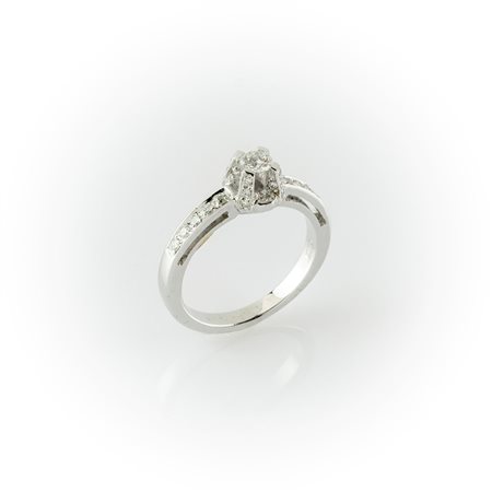 Anello in oro bianco con diamante centrale taglio brillante e pavè di diamanti laterale montato sul gambo    