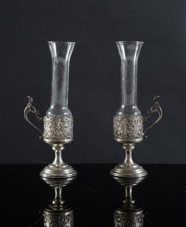 Italia, XX secolo. Coppia di portabicchierini in argento 800, con bicchiere...