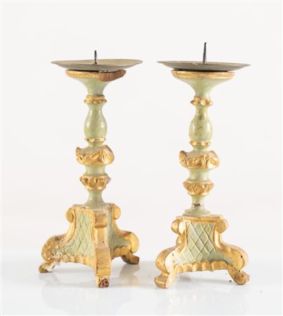 Coppia di piccoli candelabri in legno intagliato, laccato e dorato. Italia,...