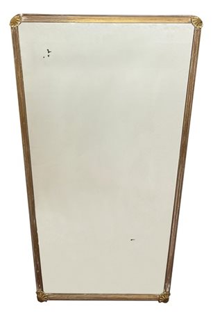 Specchio di forma sagomata con cornice in ottone scanalato decorata agli angoli