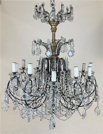 Lampadario a dodici luci con fusto in legno dorato e bracci in metallo a voluta