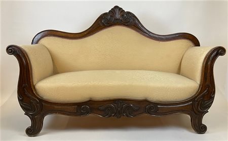 Divano a barca in legno intagliato con fronte e cimasa decorati a volute. Secol