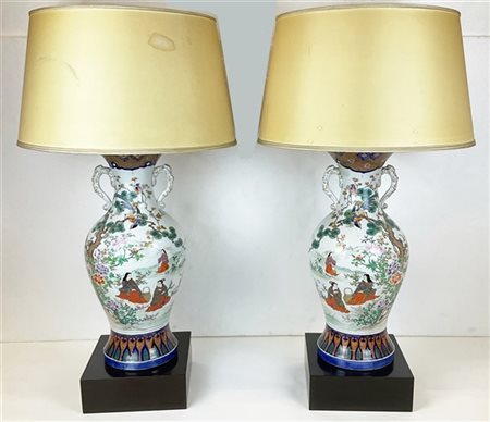 Coppia di vasi biansati in porcellana policroma decorati con figure in un giard