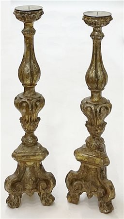 Coppia di candelieri in legno intagliato e dorato a mecca con base tripode a vo