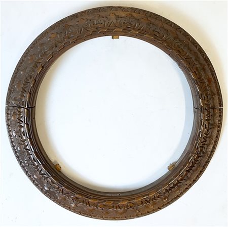 Cornice in legno intagliato di forma circolare e decorata a motivi fogliati. Re