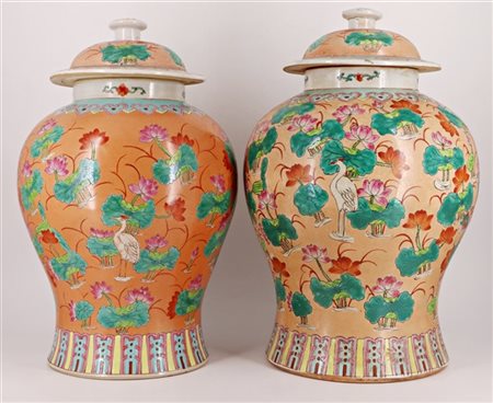 Due potiche in porcellana a fondo arancio decorati a motivi floreali recanti ma